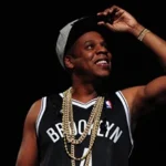 Hip-hop artist performing live at Barclays Center wearing a Brooklyn jersey and gold chains